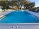 Large community pool for residents, surrounded by seating and lush landscaping at 811 Helmsman Way, Palm Harbor, FL 34685