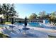 Community pool with tables, chairs, umbrellas, and lounge chairs ready for residents to enjoy the water at 811 Helmsman Way, Palm Harbor, FL 34685