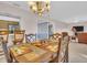 Cozy dining room with chandelier, table, and chairs near the living room and kitchen at 811 Helmsman Way, Palm Harbor, FL 34685