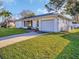 Charming single-story home with a well-manicured lawn and attached one-car garage at 811 Helmsman Way, Palm Harbor, FL 34685