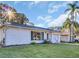 Charming single-story home with a well-manicured lawn, mature landscaping, and neutral color palette at 811 Helmsman Way, Palm Harbor, FL 34685