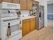 Bright kitchen features white appliances and light wood cabinetry with laminate flooring at 811 Helmsman Way, Palm Harbor, FL 34685