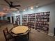Well-stocked library with an octagonal card table for board or card games and a billiards room in the background at 811 Helmsman Way, Palm Harbor, FL 34685