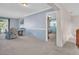 Open-concept living room with neutral decor and views into the bedroom and outside at 811 Helmsman Way, Palm Harbor, FL 34685