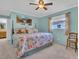 Inviting main bedroom with a queen size bed, ceiling fan, and a connecting bathroom at 811 Helmsman Way, Palm Harbor, FL 34685