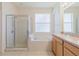 Well-lit bathroom featuring a glass-enclosed shower and a separate tub at 8329 Moccasin Trail Dr, Riverview, FL 33578