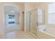 Bathroom offering a glass shower enclosure, soaking tub, and tile flooring at 8329 Moccasin Trail Dr, Riverview, FL 33578