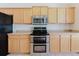 Modern kitchen with stainless steel microwave and double oven, and light wood cabinets with white backsplash at 8329 Moccasin Trail Dr, Riverview, FL 33578