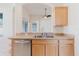 A stainless steel dishwasher and double sink under the light colored counter in a bright, open kitchen at 8329 Moccasin Trail Dr, Riverview, FL 33578