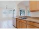 Kitchen sink area with stainless steel dishwasher, cabinets, and an archway to the breakfast nook in a bright open space at 8329 Moccasin Trail Dr, Riverview, FL 33578