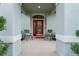 Welcoming front porch with a red door, neutral walls, and seating area at 8961 Garden Party Dr, Land O Lakes, FL 34637