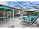 A beautiful screened-in pool with lots of seating space, an outdoor kitchen, and toys at 8961 Garden Party Dr, Land O Lakes, FL 34637