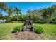 Outdoor brick firepit area surrounded by lush tropical landscaping in the backyard at 1009 Brookside Dr, Clearwater, FL 33764