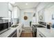 Well-lit kitchen with stainless steel appliances, white cabinets, quartz countertops, and sleek fixtures, showcasing modern elegance at 101 Sunlit Cove Ne Dr, St Petersburg, FL 33702