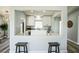 Modern kitchen with white cabinets, quartz countertops, and a peninsula counter with seating at 101 Sunlit Cove Ne Dr, St Petersburg, FL 33702