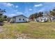 Backyard view with grassy yard, two houses and a camper on a sunny day at 1019 Canal St, Ruskin, FL 33570