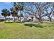 Front yard view of house with mature trees, grassy yard and RV in the driveway at 1019 Canal St, Ruskin, FL 33570