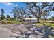 A home with mature trees providing shade, a well-kept lawn, and a driveway leading up to the residence at 1019 Canal St, Ruskin, FL 33570