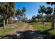 A property featuring a cleared path amid mature trees and landscaping, offering privacy at 1019 Canal St, Ruskin, FL 33570