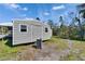 Exterior shot of a small metal shed with a gray door, windows, and a gravel base at 1019 Canal St, Ruskin, FL 33570