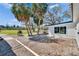 Exterior view of backyard, with a grill, palm trees, and the side of the home at 1019 Canal St, Ruskin, FL 33570