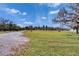 Expansive yard with green grass and a long driveway, leading to a house in the distance at 1019 Canal St, Ruskin, FL 33570