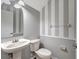 Charming powder room features striped walls, pedestal sink and toilet at 10909 Observatory Way, Tampa, FL 33647