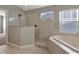 Bright bathroom features a soaking tub, a glass-enclosed shower, and white tile at 10909 Observatory Way, Tampa, FL 33647