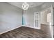 This bedroom features hardwood floors, light grey walls, and a modern light fixture at 10909 Observatory Way, Tampa, FL 33647