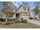 Two-story beige house with well maintained yard and mature landscaping at 10909 Observatory Way, Tampa, FL 33647