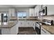 Well-lit kitchen features white cabinets, granite countertops, stainless steel appliances, and an island at 10909 Observatory Way, Tampa, FL 33647