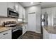 Modern kitchen featuring stainless steel appliances, granite countertops, and white cabinets at 10909 Observatory Way, Tampa, FL 33647