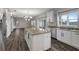 Open kitchen with island, white cabinets, granite countertops, stainless steel appliances, and wood flooring at 10909 Observatory Way, Tampa, FL 33647