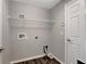Convenient laundry room with a wire rack and modern wood-look flooring at 10909 Observatory Way, Tampa, FL 33647