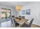 Dining area with seating for six, stylish lighting fixture, and sliding glass door to the backyard at 1109 Lady Gouldian Ct, Tampa, FL 33613