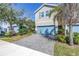 Two-story townhome with neutral siding, a blue garage door and brick paver driveway at 1109 Lady Gouldian Ct, Tampa, FL 33613