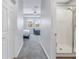 Hallway with a full bathroom with glass shower, door, and bedroom with two windows at 1109 Lady Gouldian Ct, Tampa, FL 33613