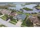 Aerial view of the home, lush landscaping, private pool, and waterfront with dock access at 1204 Blackrush Dr, Tarpon Springs, FL 34689