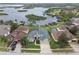 Aerial view of the home, lush landscaping, private pool, and waterfront with dock access at 1204 Blackrush Dr, Tarpon Springs, FL 34689