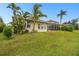Lush, tropical landscaping frames the backyard and screened in pool at 1204 Blackrush Dr, Tarpon Springs, FL 34689