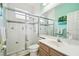 Bathroom with a glass-enclosed shower, white vanity, and stylish tile accents at 1204 Blackrush Dr, Tarpon Springs, FL 34689