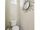 Powder room with an artistic mirror, toilet, and natural light at 1204 Blackrush Dr, Tarpon Springs, FL 34689