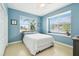 Bright bedroom featuring two windows, a ceiling fan, a double bed, and light wood floors at 1204 Blackrush Dr, Tarpon Springs, FL 34689