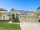 Attractive home with a well-maintained yard, mature landscaping, and an attached three-car garage at 1204 Blackrush Dr, Tarpon Springs, FL 34689