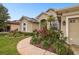 Landscaped front yard with a variety of plants and flowers, leading to a welcoming entrance at 1204 Blackrush Dr, Tarpon Springs, FL 34689