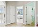 Bright hallway showcasing doors to a bedroom, bathroom, and living area with abundant natural light at 1204 Blackrush Dr, Tarpon Springs, FL 34689