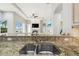 Kitchen sink with granite counter overlooking a living area with fireplace and water view at 1204 Blackrush Dr, Tarpon Springs, FL 34689