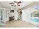 Bright living room featuring a cozy fireplace and a view of the pool through large sliding glass doors at 1204 Blackrush Dr, Tarpon Springs, FL 34689