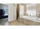 Stunning bathroom with tub, glass block window, and a separate walk-in shower at 1204 Blackrush Dr, Tarpon Springs, FL 34689