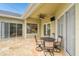 Covered outdoor patio with travertine tile, ceiling fan, and dining table at 1204 Blackrush Dr, Tarpon Springs, FL 34689